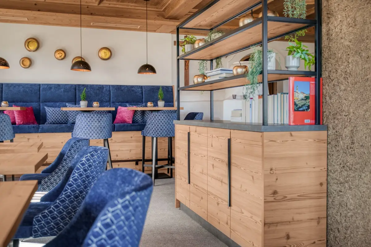 Bar with blue upholstered benches and an open shelving wall