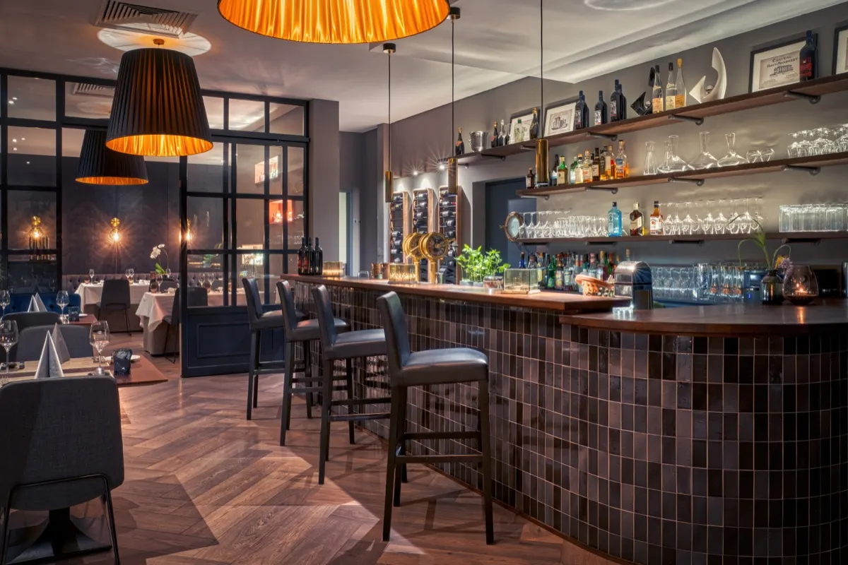 Bar counter with orange shaded lamps and herringbone parquet