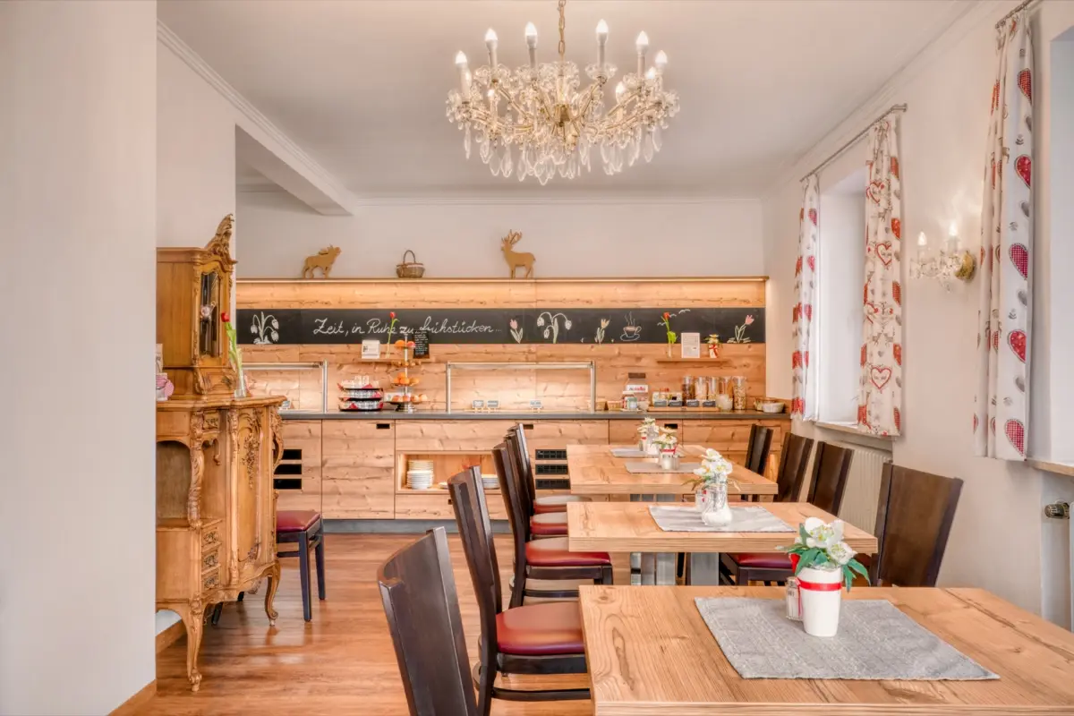 Bright breakfast room with a chandelier and laid tables