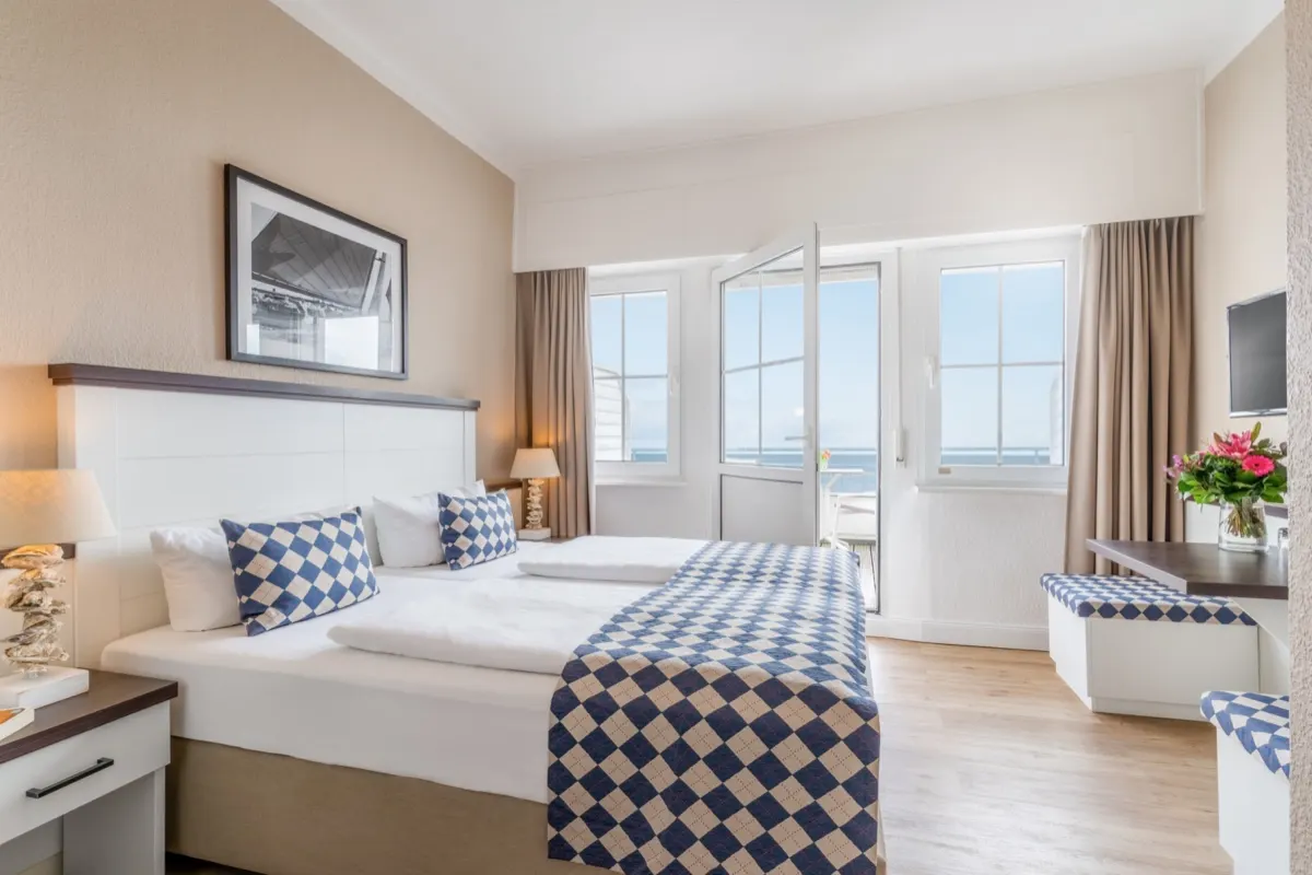 Hotel room in blue and white with balcony door and a view of the Baltic
