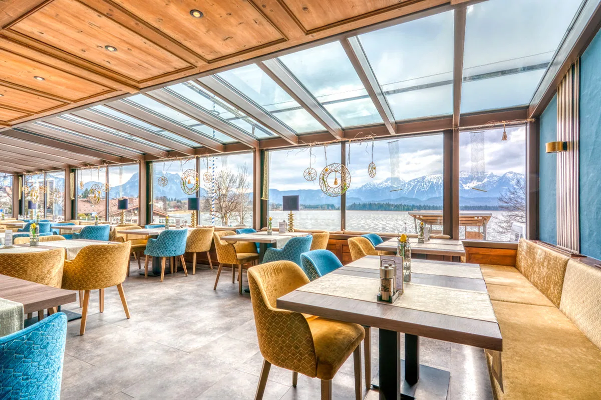 Panoramarestaurant mit Glasdach und Fensterfront auf die verschneiten Berge
