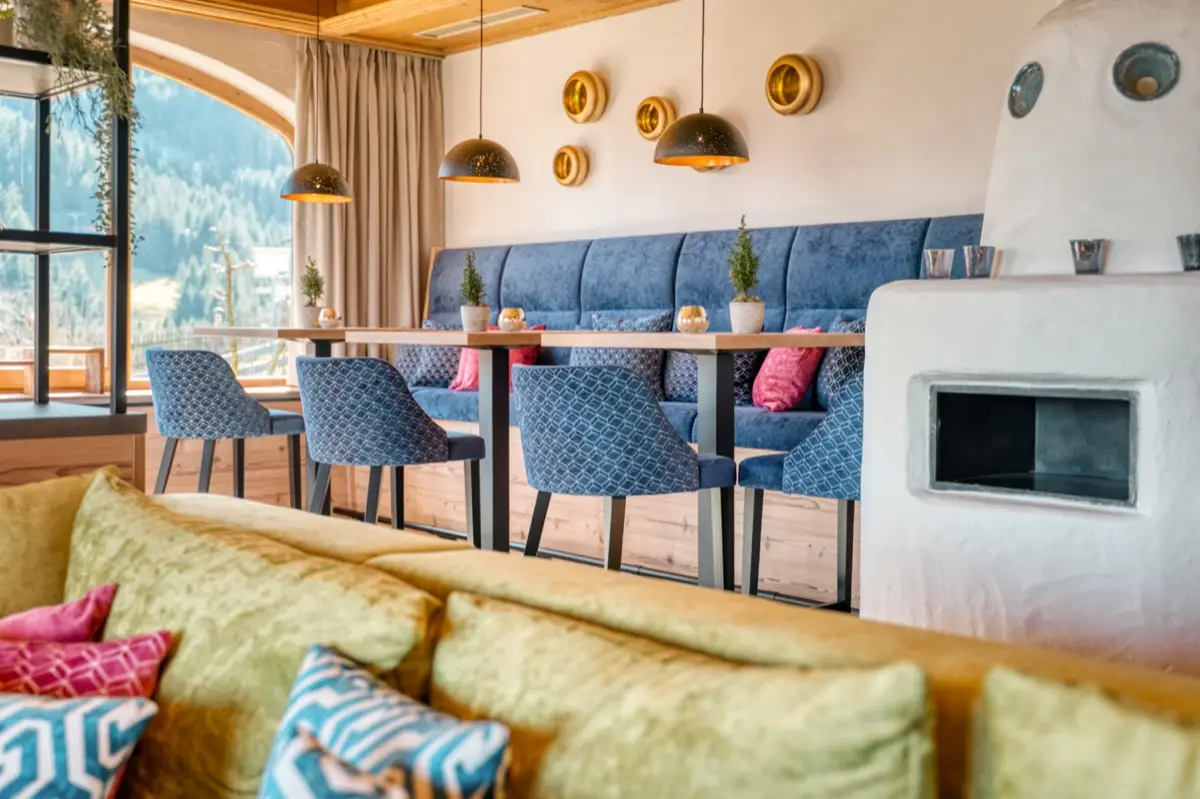 Upholstered bench beside a white tiled stove