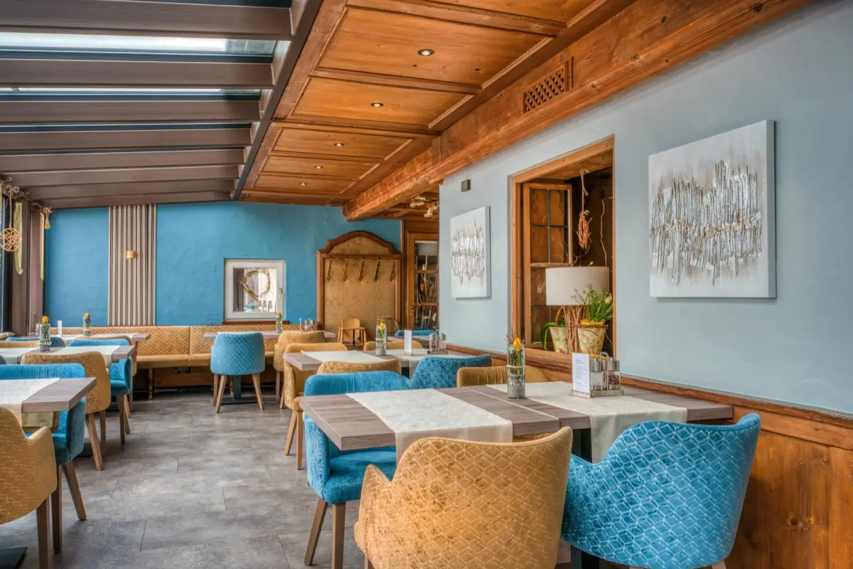 Parlour with a blue wall, timber ceiling and a mixed seating group