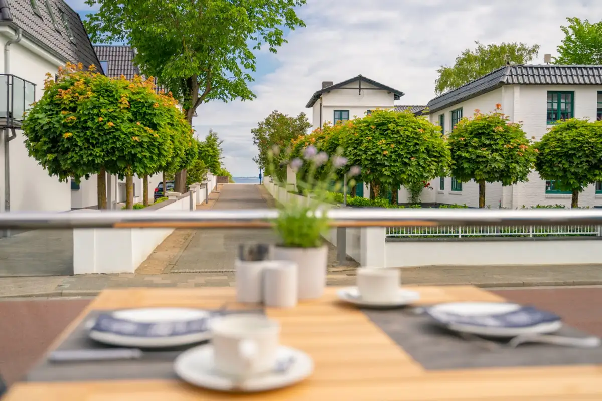 Laid terrace table looking down an avenue towards the Baltic