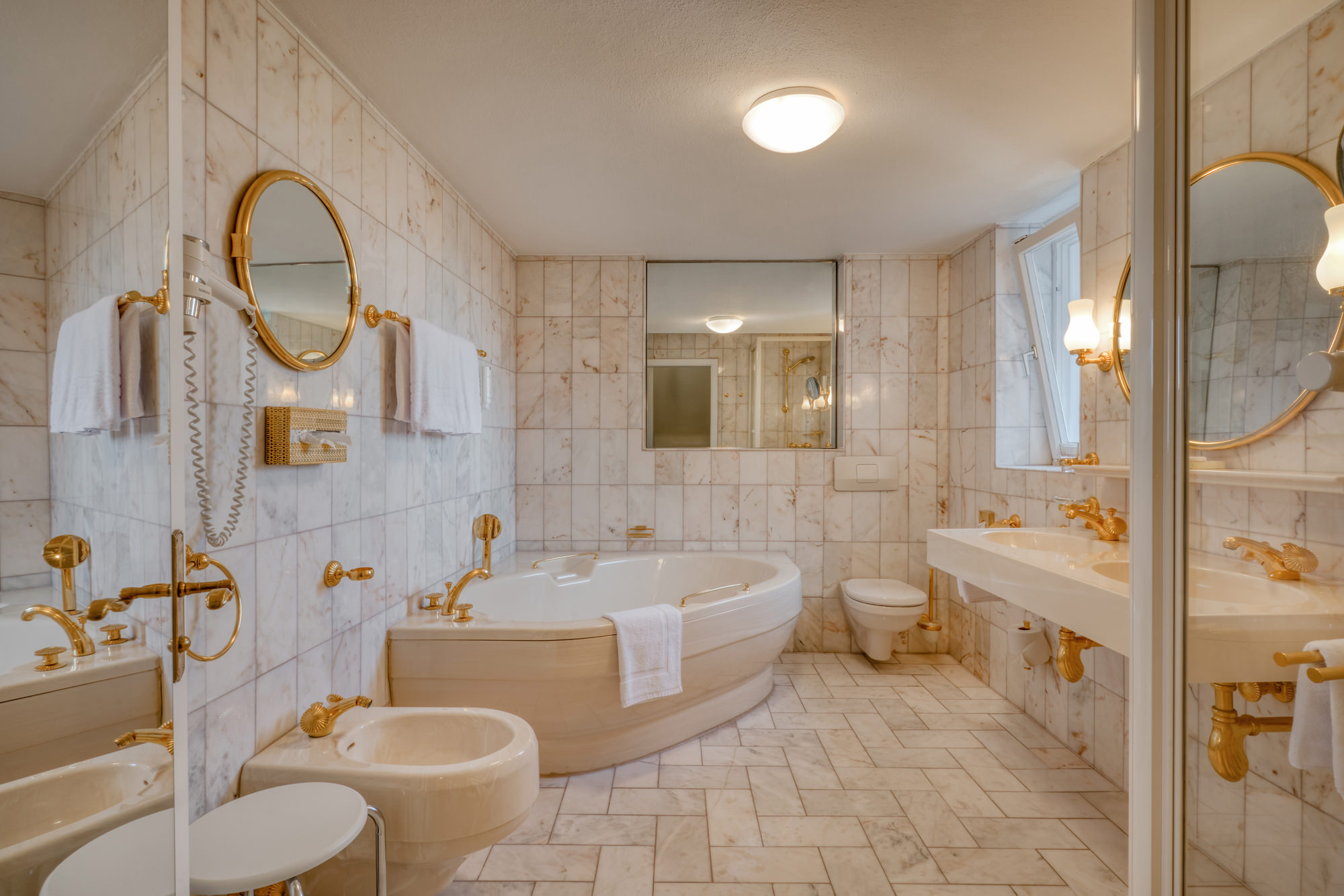 Badezimmer mit Marmoroptik und Goldarmaturen